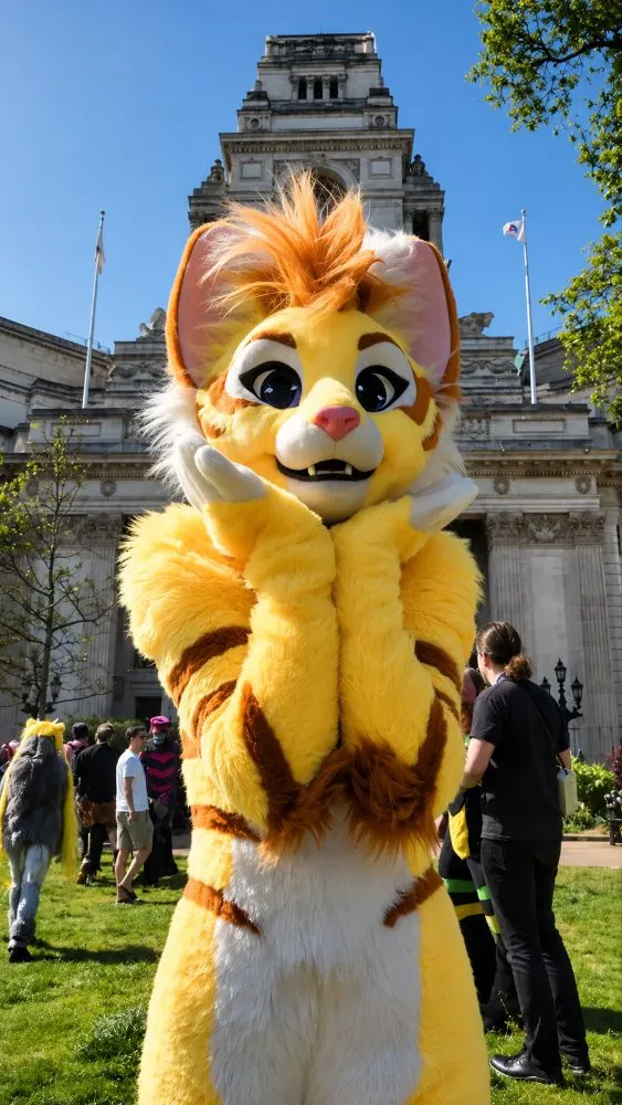 Yellow tiger fursuit outdoors at a convention